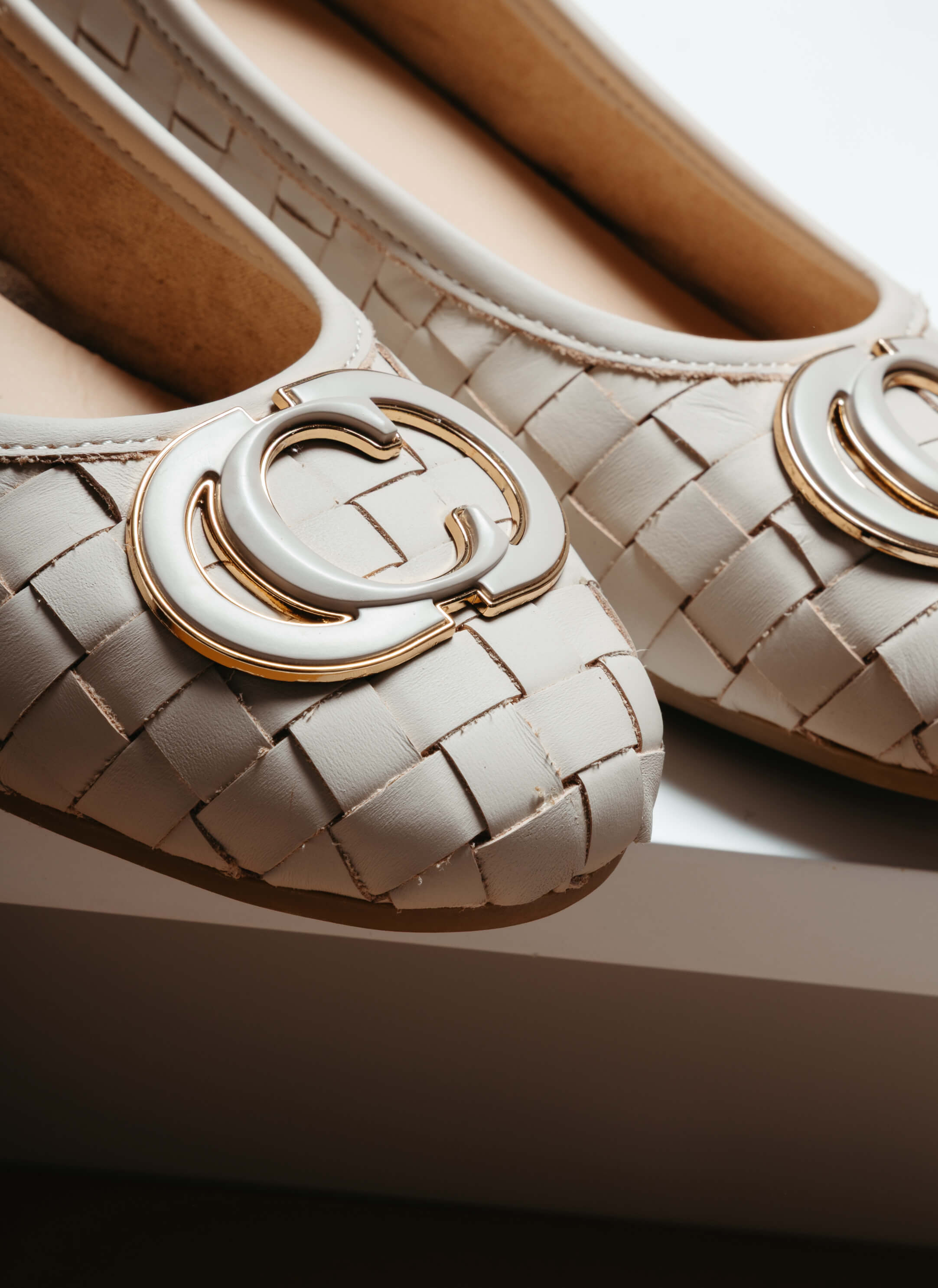 Weißer Leder-Ballerina mit geflochtenem Muster und goldener Zierspange