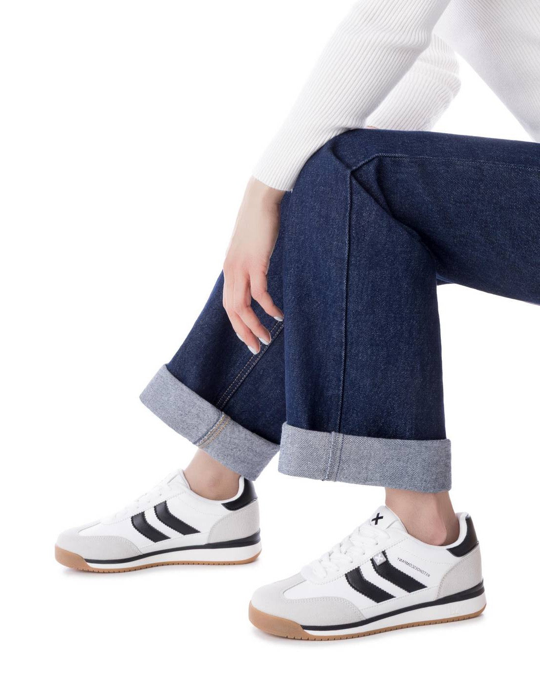 Weiß-schwarzer Retro-Sneaker mit sportlicher Linienführung und Kontrastdetails